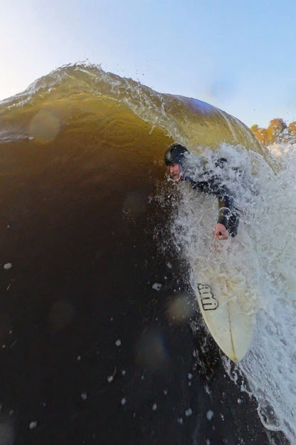 Surfer getting barreled with the soft surfing helmet made by Sjø Protection.