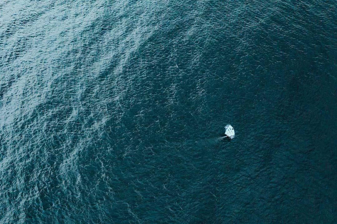 Wing foiler surfing in the ocean at high speed seen from a drone.