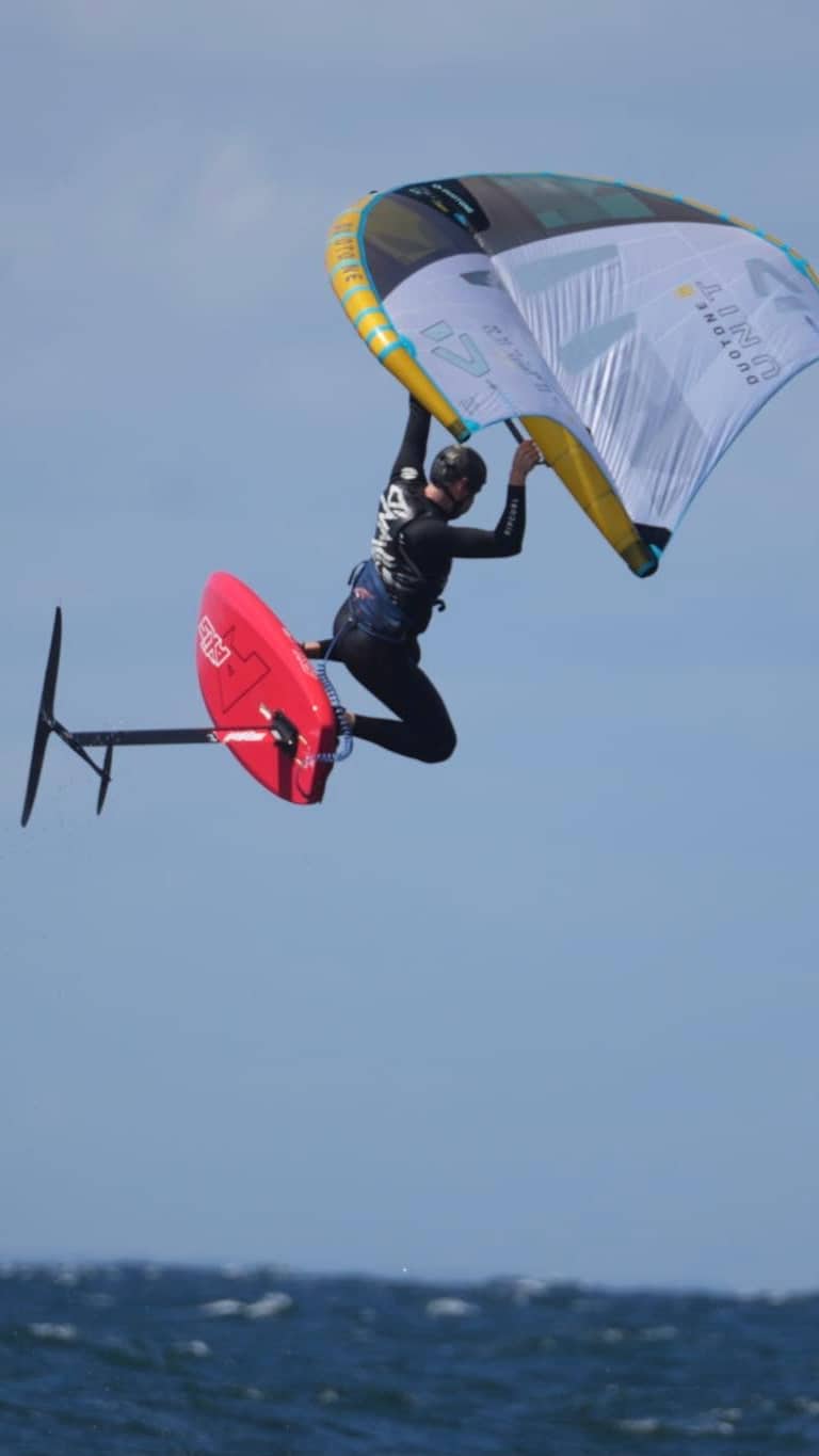 Customer jumping with his wingfoil gear while wearing our soft surf helmet.
